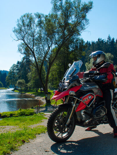 Biker macht Halt an einem See auf der Motorradtour Dreiländereck in Deutschland